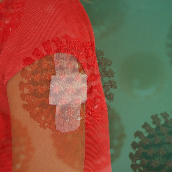 Coronaviruses fade to the background on a young girl's arm whose bandages indicate she has had the vaccine. Photo © FreeImages.com/Paul de Bruin