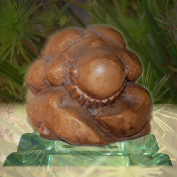 A wooden Zen statuette sits atop a crystal pyramid against a backdrop of wispy, green plants. Photos © FreeImages.com/Marcelo Gerpe