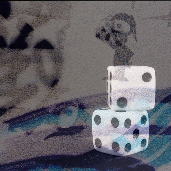 Two dice sit in front of a sandstone-esque petroglyph of an explorer overlooking a foreign landscape. (Photos © FreeImages/Maria Kaloudi and Dora Mitsonia)
